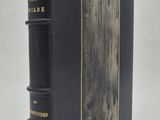 un livre noir orné de lettres dorées, posé sur une surface blanche