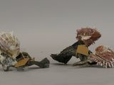two figurines of a man and a woman sitting on a rock