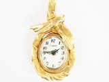 une image représentant une horloge plaquée or avec une feuille sur le cadran