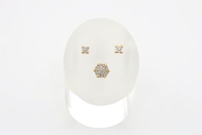 un gros plan sur un œuf blanc sur lequel sont posées une paire de boucles d'oreilles