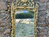 un miroir accroché à un mur, avec un mur en pierre en arrière-plan