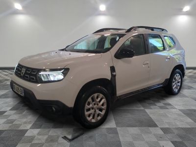 La Dacia blanche est garée dans une grande pièce au sol carrelé en damier.