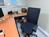 une chaise de bureau noire assise devant un bureau d'ordinateur