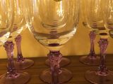 Plusieurs verres à vin sont alignés en rang sur une table