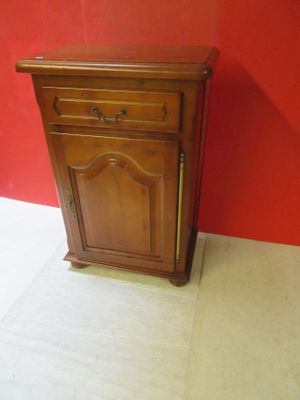 an image of a small wooden cabinet against a red wall