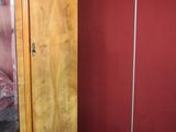 un rouleau de papier toilette posé par terre à côté d'une armoire