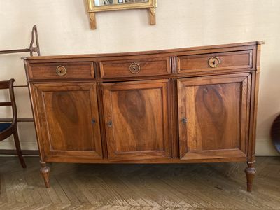 une armoire en bois à deux portes et un miroir accroché au mur