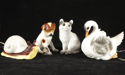 five figurines of cats and swans on a black background