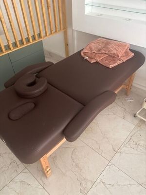 une table de massage recouverte d'une serviette, dans une pièce