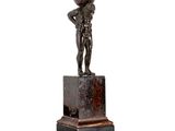une statue en bronze représentant un garçon avec un ballon sur la tête