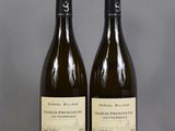 two bottles of wine sit side by side on a table