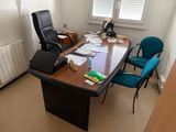 a desk with a chair and a desk top with papers on it