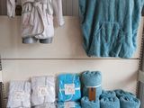 une étagère sur laquelle sont posés des serviettes, des couvertures et d'autres objets