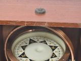 a small wooden box with a compass inside of it