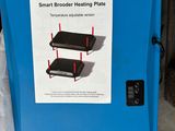 une boîte bleue sur laquelle est apposée une étiquette indiquant « plaque chauffante Smart Broder »