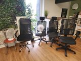plusieurs chaises de bureau et un ventilateur dans une pièce au sol en parquet