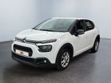 Une Citroën blanche est garée dans une pièce blanche