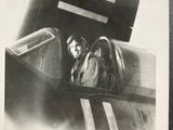 black and white photograph of a woman sitting in the cockpit of a plane