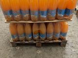 several bottles of orange juice are stacked on a pallet