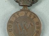 an old medal with a crown on top of it sitting on a table