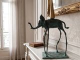 a statue of an elephant on a mantle in a room