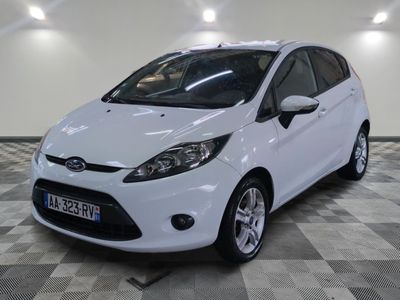 la voiture blanche est garée sur un sol en damier dans le garage