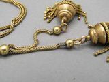 a gold necklace with a gold bead and a gold chain