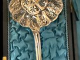 une cuillère en argent ornée d'une fleur, dans une boîte