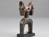 une sculpture en bois représentant une tête de cheval posée sur un socle noir