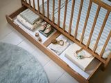 un lit de bébé avec un sommier et un tiroir en dessous