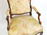 une chaise à l'ancienne dont l'assise est recouverte d'un tissu à motifs floraux