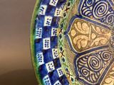 a blue and green plate with a design on it