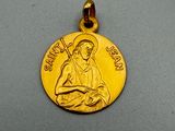 un gros plan d'une médaille d'or posée sur une surface grise