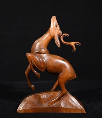 une sculpture en bois représentant un cheval sur fond noir