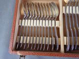 a lot of forks and spoons in a box