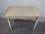 a small table with a wooden top on a cement floor