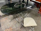 a glass table with a metal frame and chairs in a room