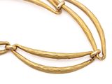 a close up of a gold bracelet on a white background