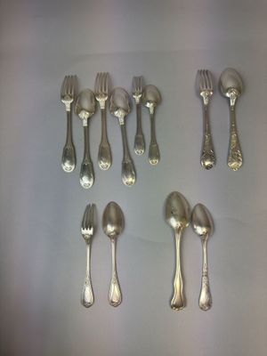 un grand nombre de cuillères et de fourchettes en argent disposées sur une table