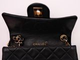 a close up of a black purse with a chain on it