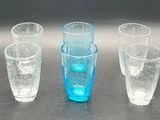 four glasses sitting on a table with water in them