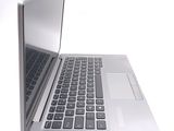 a silver laptop with a black keyboard on a white surface
