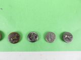 four different types of coins are shown on a green surface