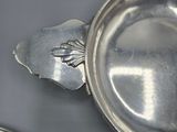 a silver plate with a bird on it on a table