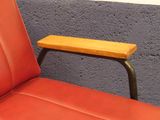a red leather chair with a small wooden table on it
