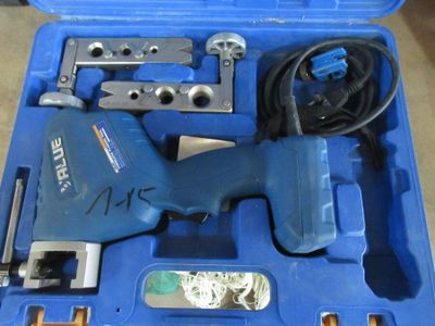 une boîte bleue contenant des outils sur le sol