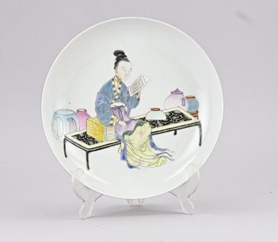 une image représentant une assiette sur laquelle est peinte une femme assise à une table