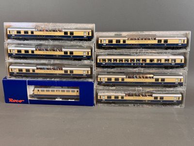 Plusieurs trains miniatures sont empilés les uns sur les autres sur une table