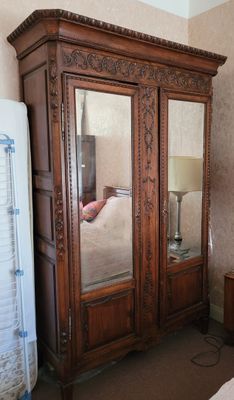 une grande armoire en bois surmontée d'un miroir