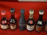 several bottles of alcohol are lined up on a red cloth